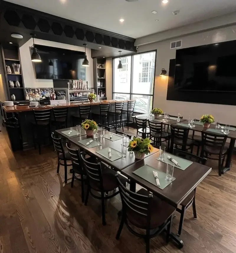 Tables in the back room by the windows, with the bar along the wall.